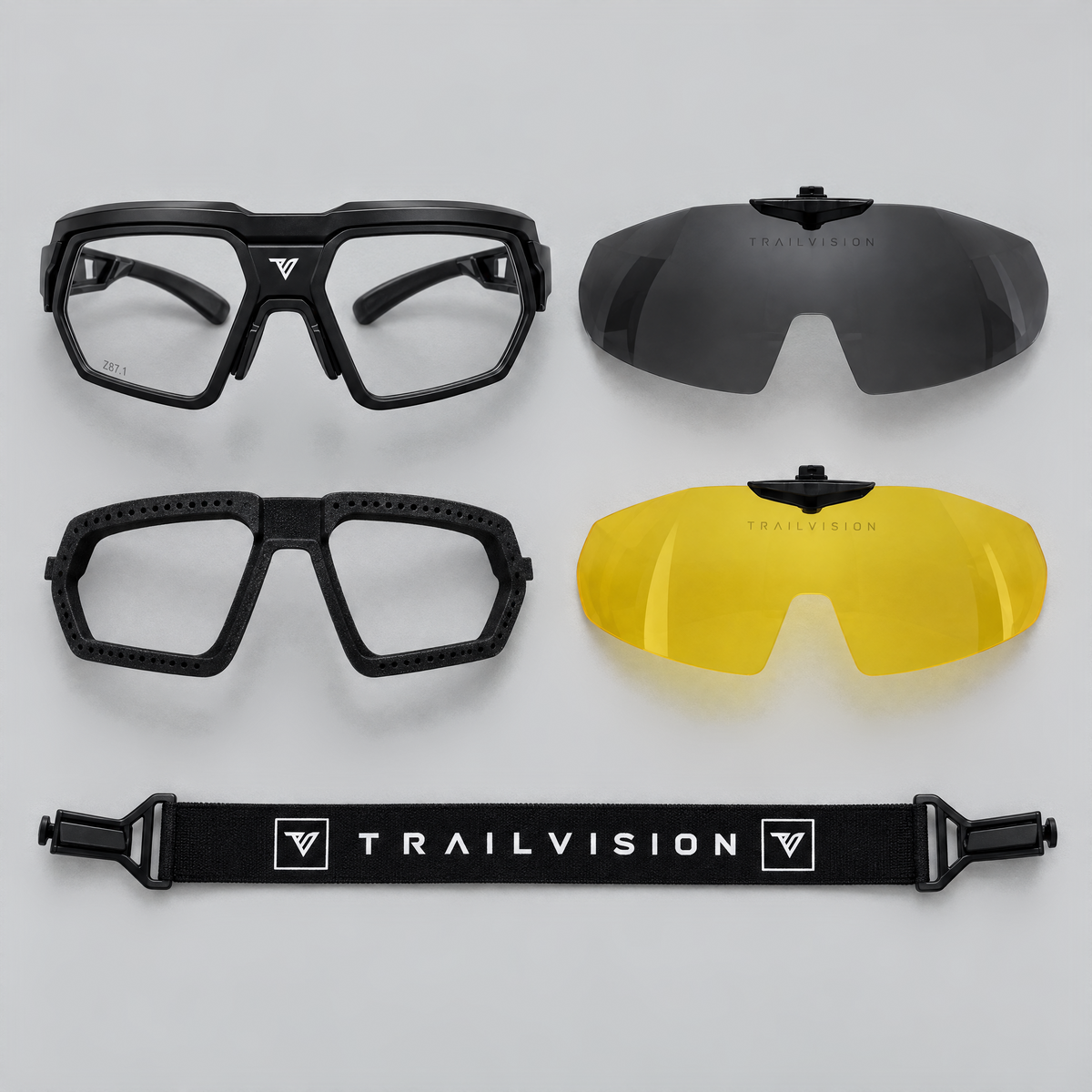 Titan kit flat lay: glasses, smoke and yellow shield clips, foam gasket and TRAILVISION strap
