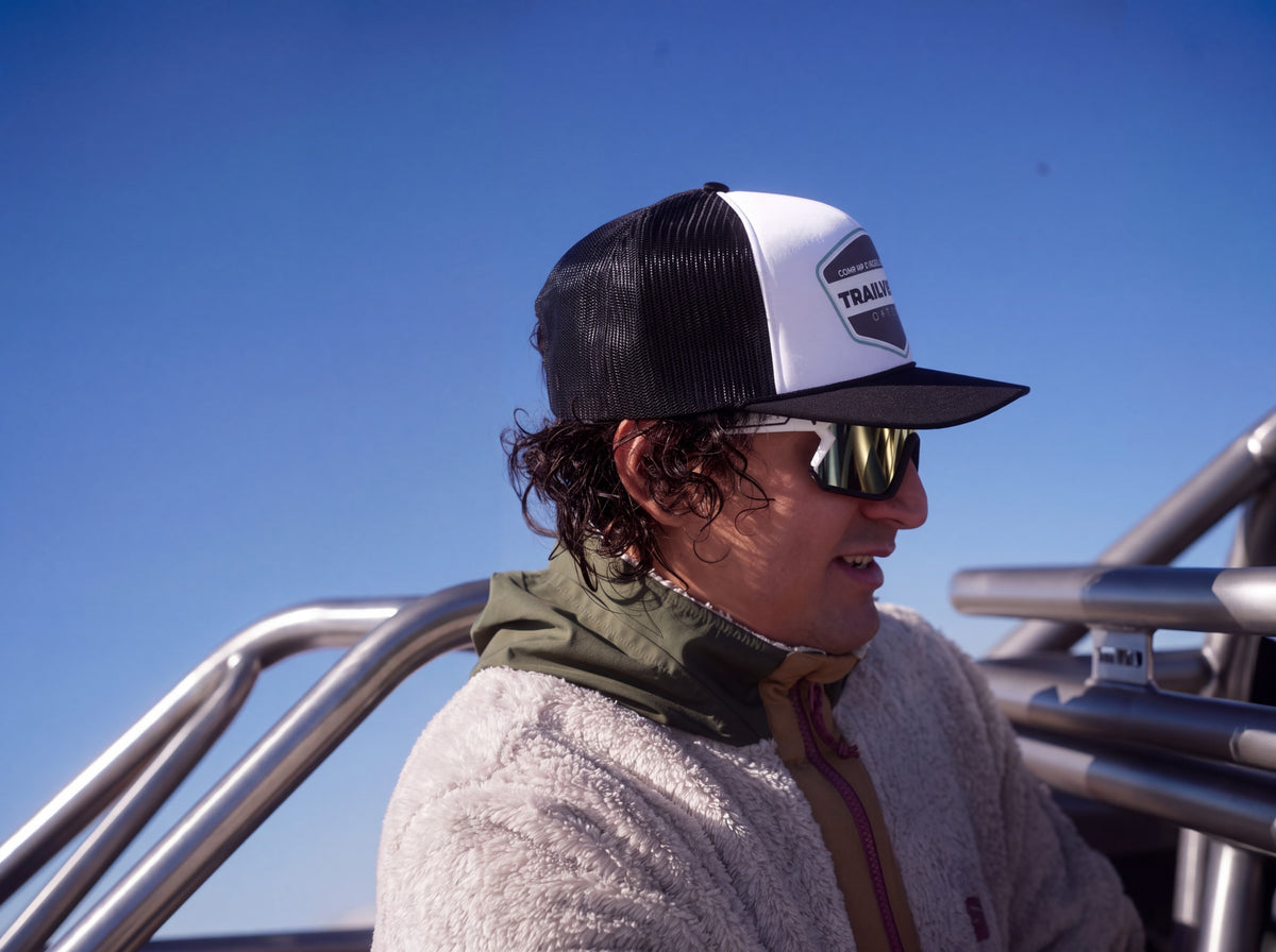 Rider in Trailvision cap and shield sunglasses in an open Jeep roll cage